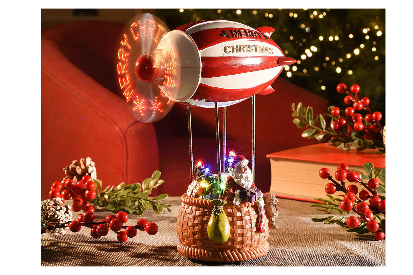 Carillon. Dirigibile Babbo Natale, eliche con scritte, musica e luci LED. Misure: cm 16,5 x 8,5 x 21. Funziona con 3 pile ministilo non incluse - Con eliche in movimento - Scatola: 20 x 13 x 26 H